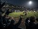 football fans close to the pitch wet night loving the action